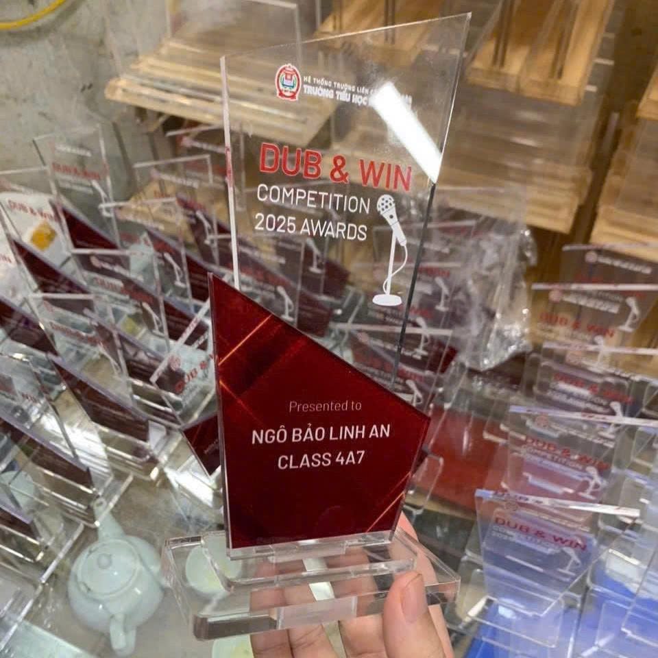 Kỷ niệm chương mica đỏ trong suốt, in logo trường tiểu học, chữ trắng nổi bật, tặng học sinh đạt giải.
